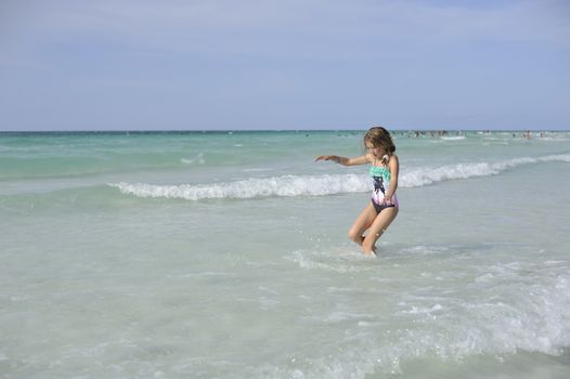 Girl on the Caribbean sunny beach with white sand.