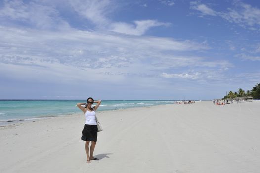 Girl on the Caribbean sunny beach with white sand.