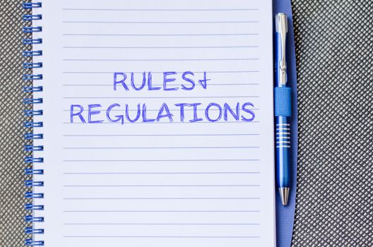 Rules and regulations text concept write on notebook with pen
