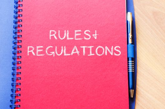 Rules and regulations text concept write on notebook with pen
