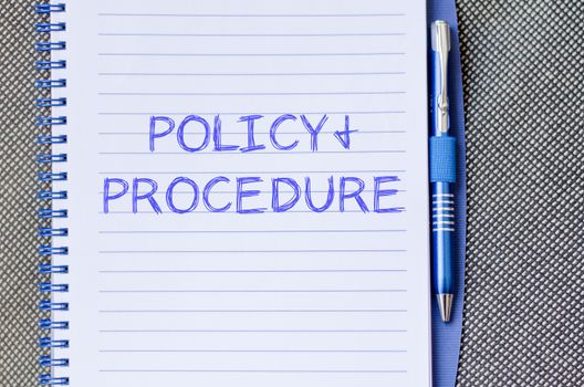 Policy and procedure text concept write on notebook with pen