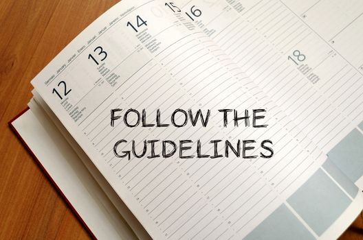 Follow the guidelines text concept write on notebook with pen