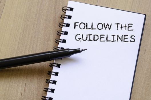 Follow the guidelines text concept write on notebook with pen