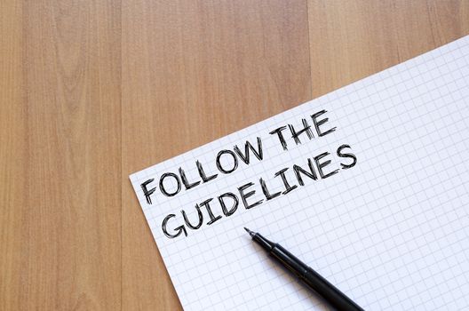 Follow the guidelines text concept write on notebook with pen