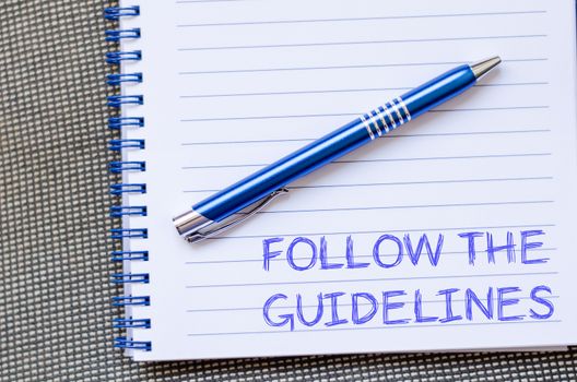 Follow the guidelines text concept write on notebook with pen