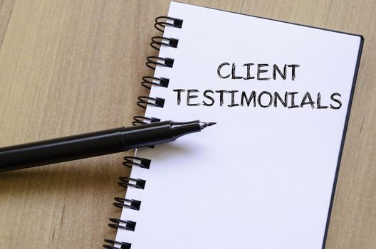 Client testimonials text concept write on notebook with pen