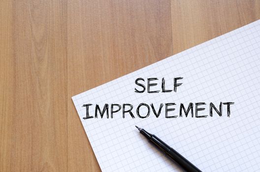 Self improvement text concept write on notebook with pen