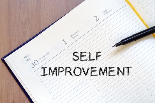 Self improvement text concept write on notebook with pen