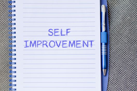 Self improvement text concept write on notebook with pen
