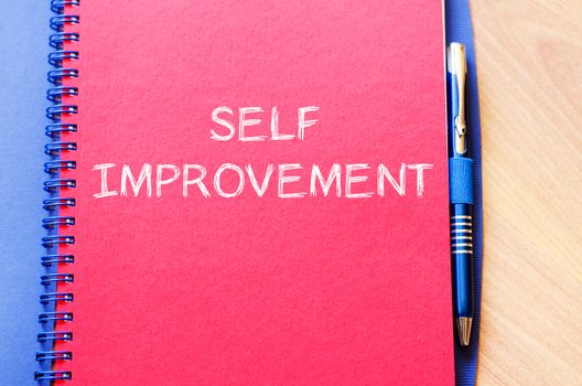 Self improvement text concept write on notebook with pen