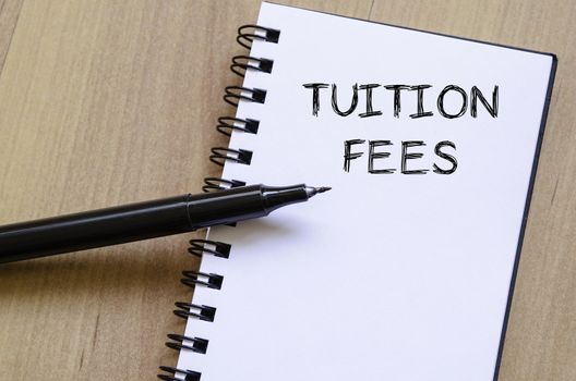 Tuition fees text concept write on notebook with pen