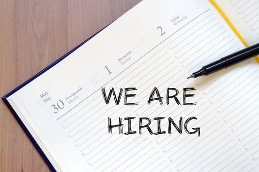 We are hiring text concept write on notebook with pen