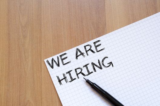 We are hiring text concept write on notebook with pen