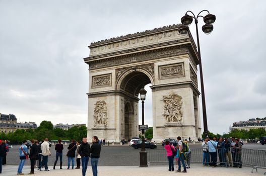 Paris, France - May 14, 2015: Tourist visit Arc de Triomphe de l'Etoile in Paris. Arc de Triomphe was built in 1806-1836 by architect Jean Shalgrenom by order of Napoleon to commemorate victories of his Army.