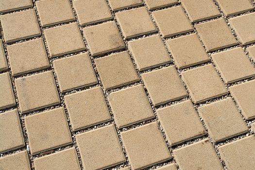 Patterned light brown paving street tiles on the road                               