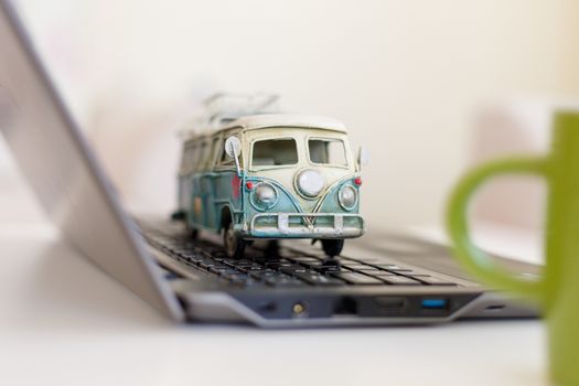 Close up detailed view of a black laptop pc with a colorful toy bus on.