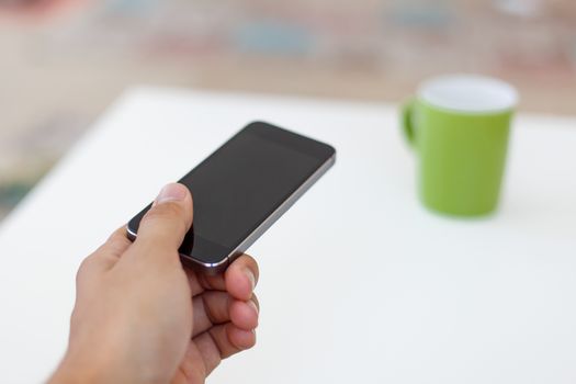 Close up detailed view of a black smart phone holding on hand.