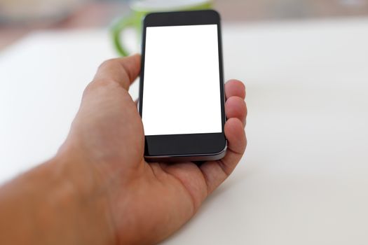 Close up detailed view of a smart phone holding on hand, with white blank copy space screen.