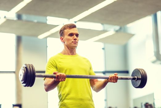 sport, fitness, lifestyle and people concept - man doing exercise with barbell in gym