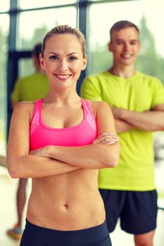 sport, fitness, lifestyle and people concept - smiling man and woman in gym