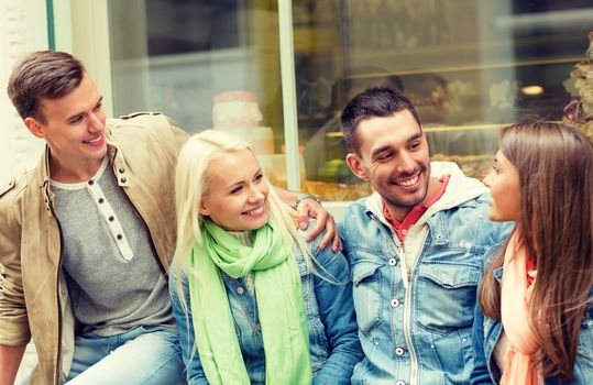 friendship, travel and vacation concept - group of smiling friends walking in the city