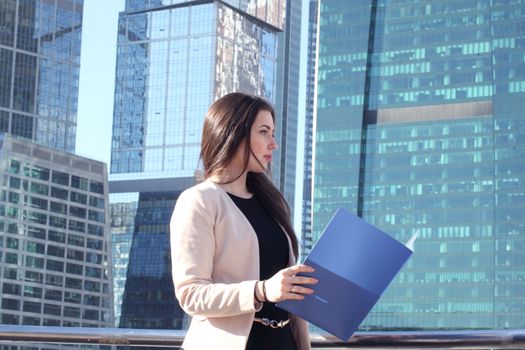 Young beautiful businesswoman outdoors at skyscraper background