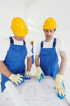 Workers looking at construction plan indoors