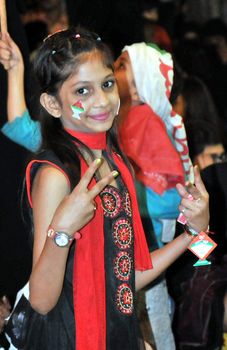PAKISTAN, Karachi: A little girl joins crowds of people gather on December 6, 2015 to celebrate the victory of Muttahida Qaumi Movement (MQM) by waving flags and dressing in the party's colours.  The MQM rejoiced over its massive victory in the third and final phase of the local government polls. The crowd gathered in Karachi's Jinnah ground while fireworks were also displayed. The results are unofficial and inconclusive but will be announced tomorrow as well as the mayor of Karachi. 