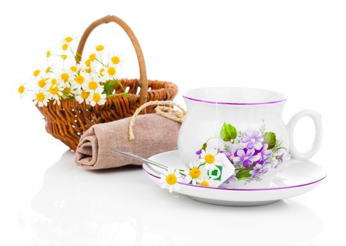 Cup with fresh camomile flower and tea bags, isolated on white