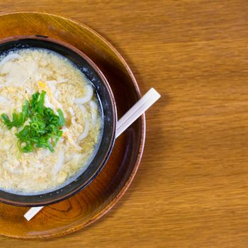 Miso Ramen Asian noodles with egg and parsley in wooden bowl on brown rustic background.