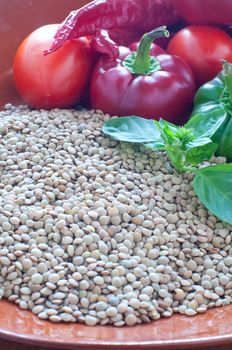 Lentils ready to be cooked with tomatoes , peppers , eggplant, italy