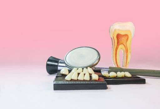 Denture material,stethoscope and model tooth on a table isolated.