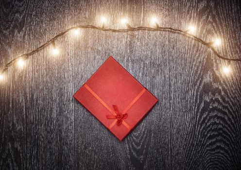 Christmas light and gift box on a hardwood background