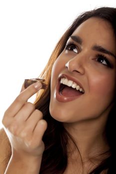 Happy young woman eating chocolate.