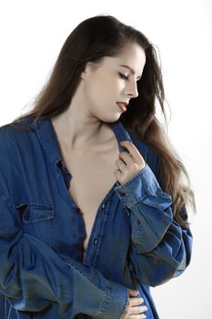 A beautiful fair skinned woman wearing a manes denim shirt over a light background.