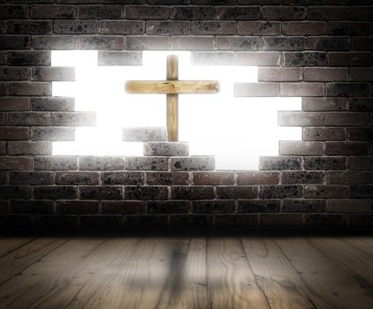 Wooden cross behind a broken brick wall with white light in the background.