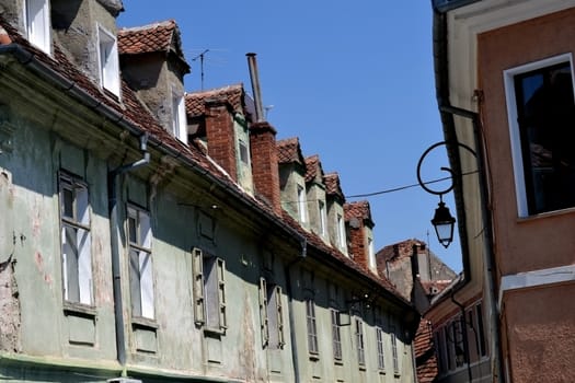 Churches, gates, towers, walls, buildings and ancient streets in downtown Brasov. Old windows, plaster slab, archways green, tourists