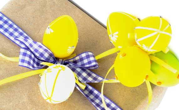 Arrangement of Easter Gifts with Checkered Ribbon and Colored Easter Eggs closeup on White background