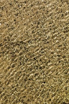 Water flowing over different coloured rocks as a abstract water background.