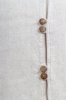 Closed up natural texture cotton fabric with wooden buttons