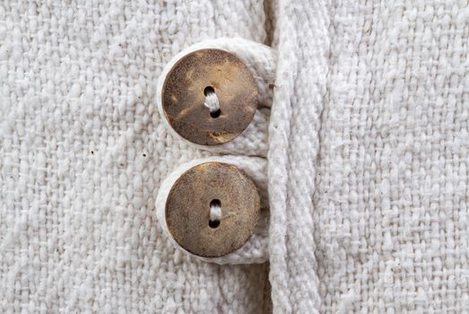 Closed up natural texture cotton fabric with wooden buttons