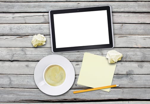 Tablet with cup of coffee and pencil on wood table