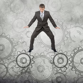 Businessman standing on cog wheels on abstract background