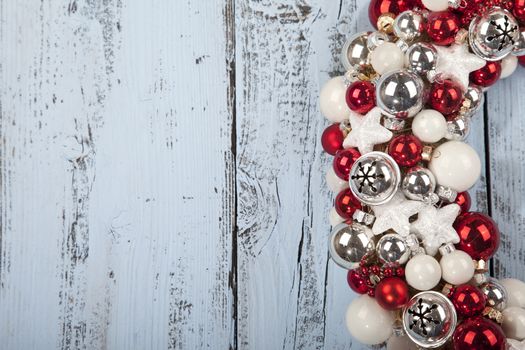 Christmas wreath with bells on light blue wooden background