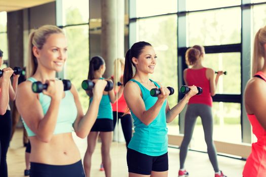 fitness, sport, training, gym and lifestyle concept - group of women with dumbbells in gym