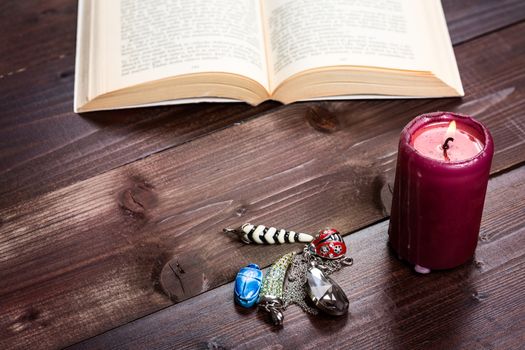 Composition of esoteric objects,candle and book used for healing and fortune-telling.