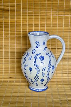 White and blue jug on bamboo material background