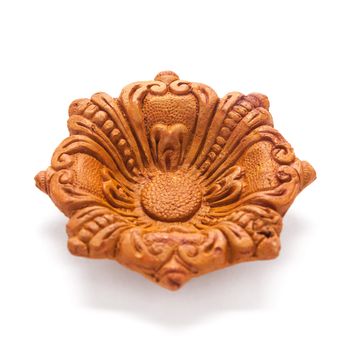 Close up of a beautifully carved designer handmade clay lamp isolated on white background.