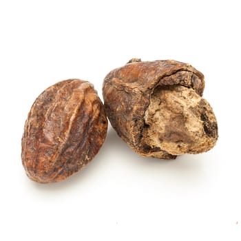 Macro closeup of a full and a cracked Organic Inknut or Harr (Terminalia chebula) isolated on white background.