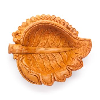Top view of a beautifully carved leaf design handmade clay lamp isolated on white background.